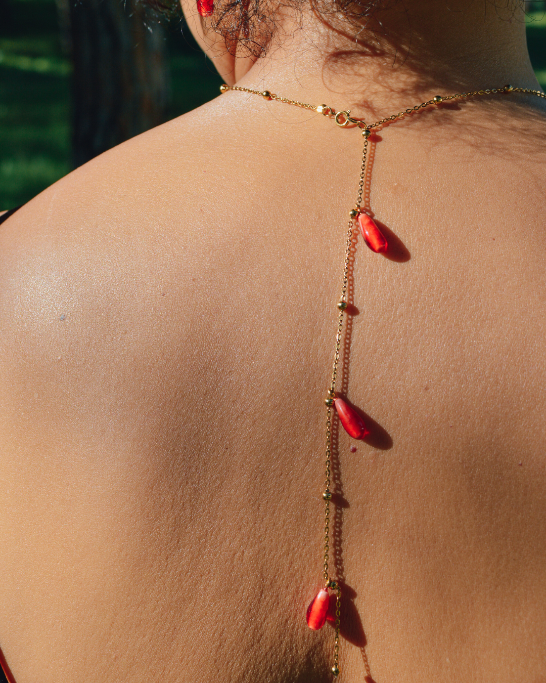 Colgante Granada La Soñadora con detalle posterior y gotas rojas sobre la espalda